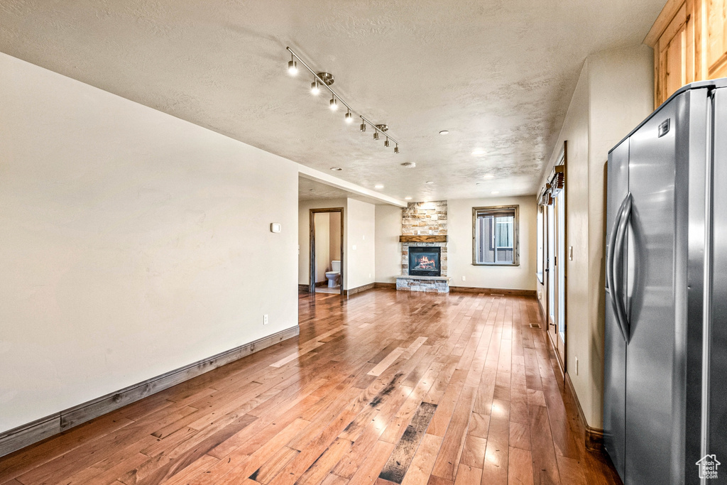 Unfurnished living room with a textured ceiling, a fireplace, and hardwood / wood-style floors