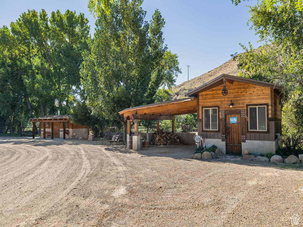 View of front of home featuring a shed and a carport