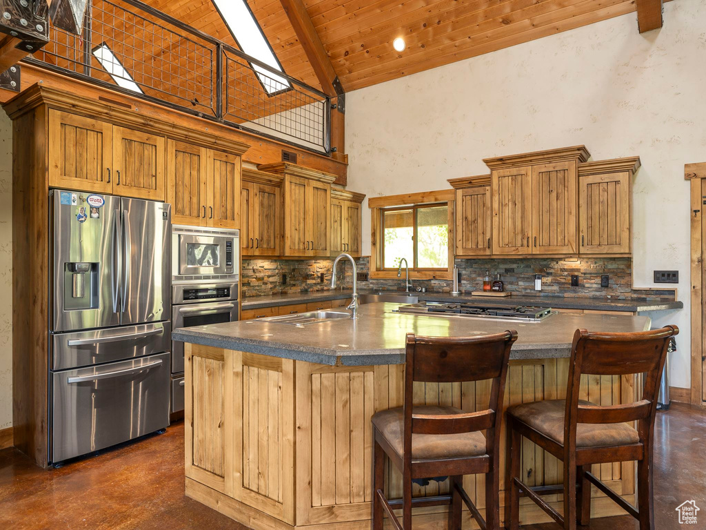 Kitchen featuring sink, wooden ceiling, stainless steel appliances, and tasteful backsplash