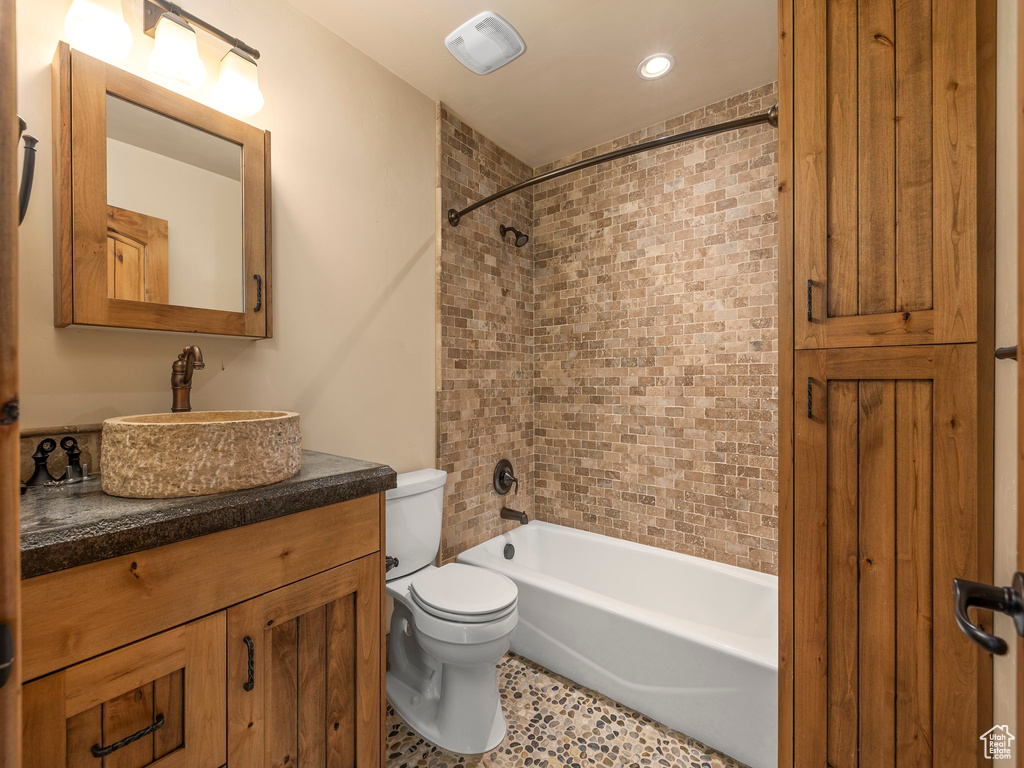 Full bathroom with vanity, toilet, and tiled shower / bath combo