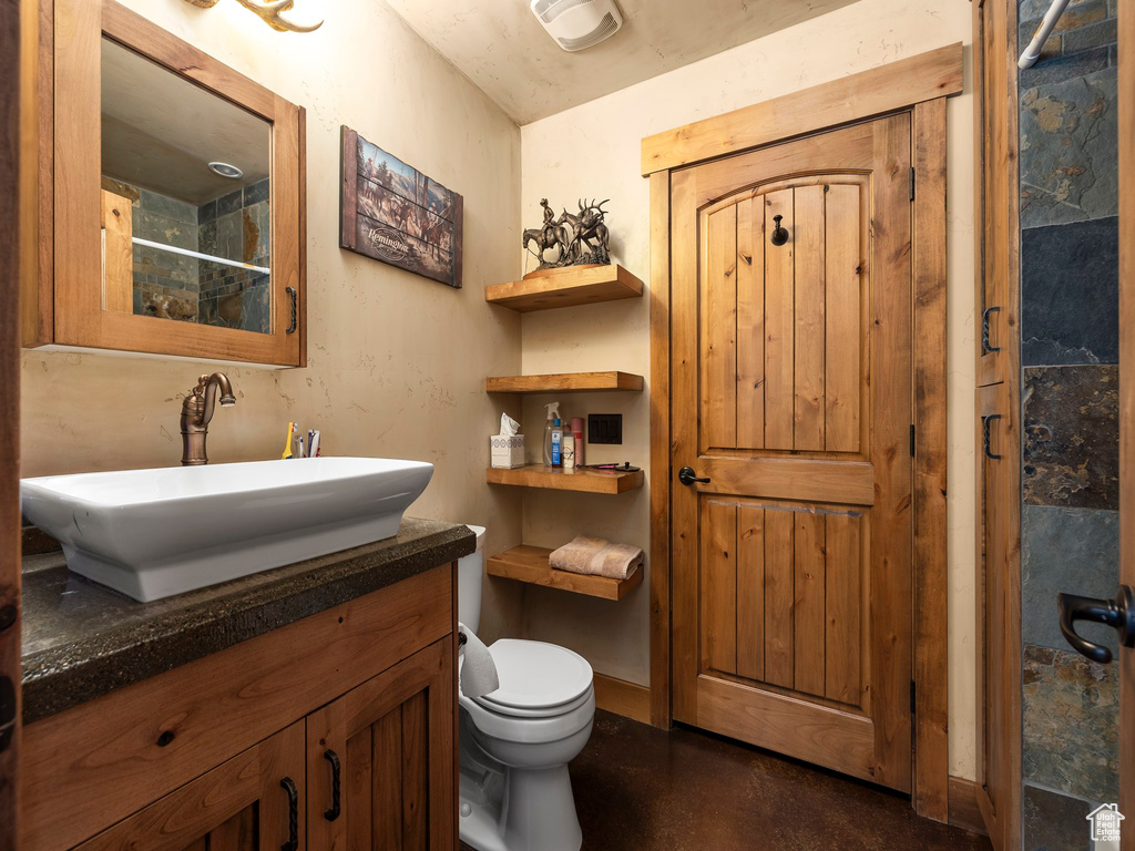 Bathroom with vanity, walk in shower, and toilet