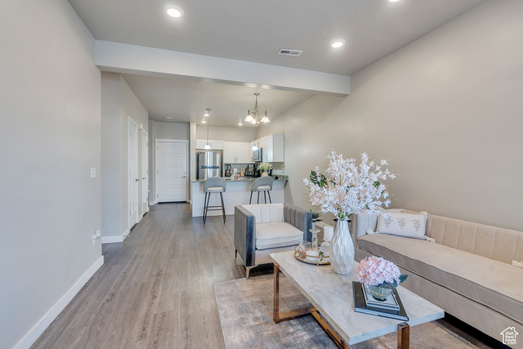 Living room featuring an inviting chandelier and light hardwood / wood-style floors