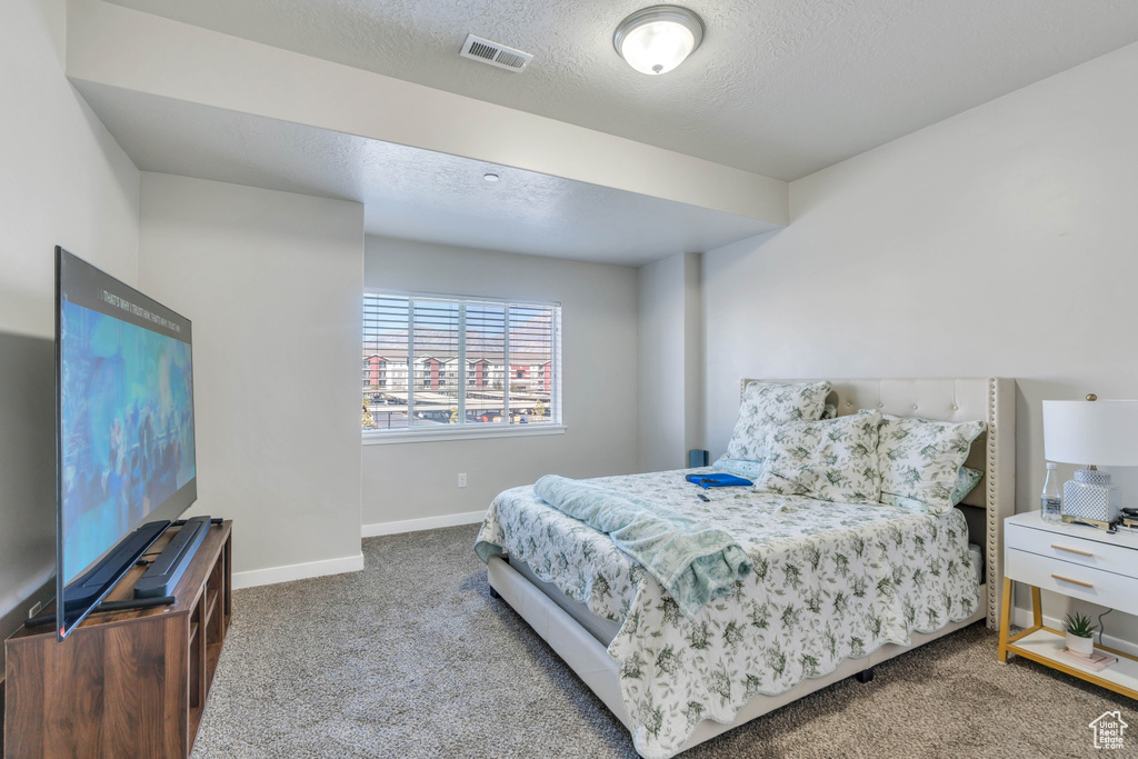 Carpeted bedroom with a textured ceiling