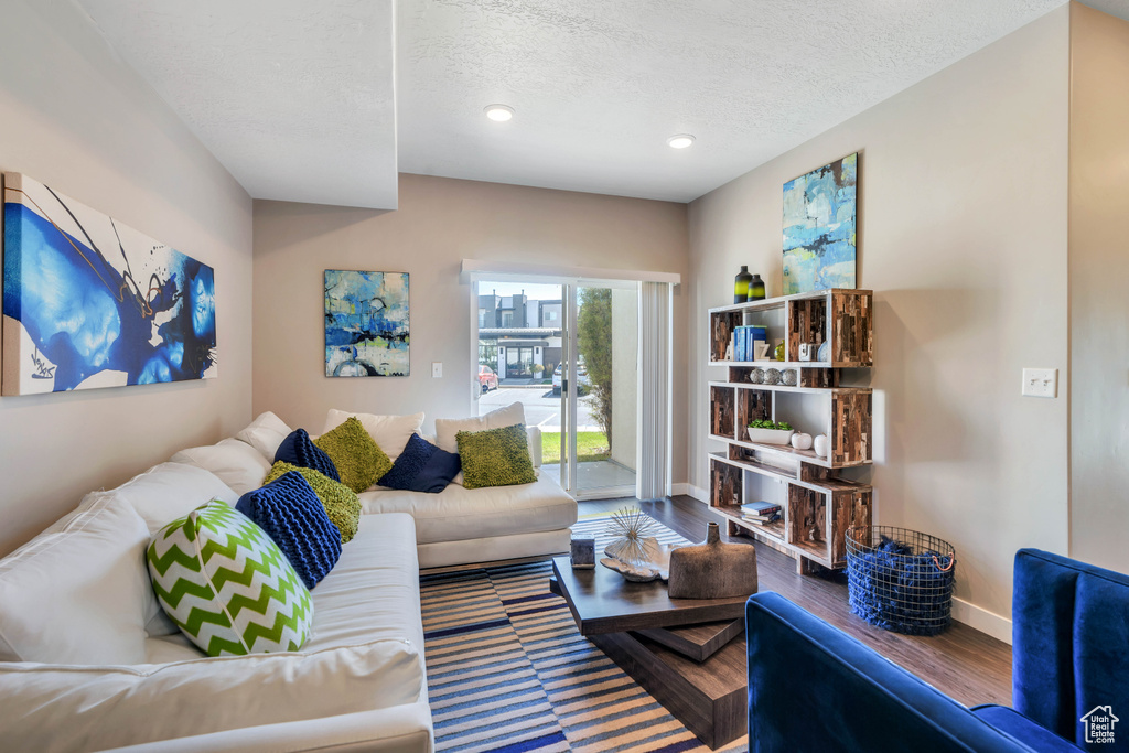 Living room with a textured ceiling and hardwood / wood-style floors