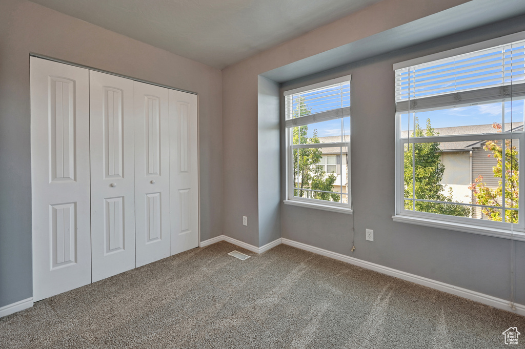 Unfurnished bedroom featuring a closet and carpet