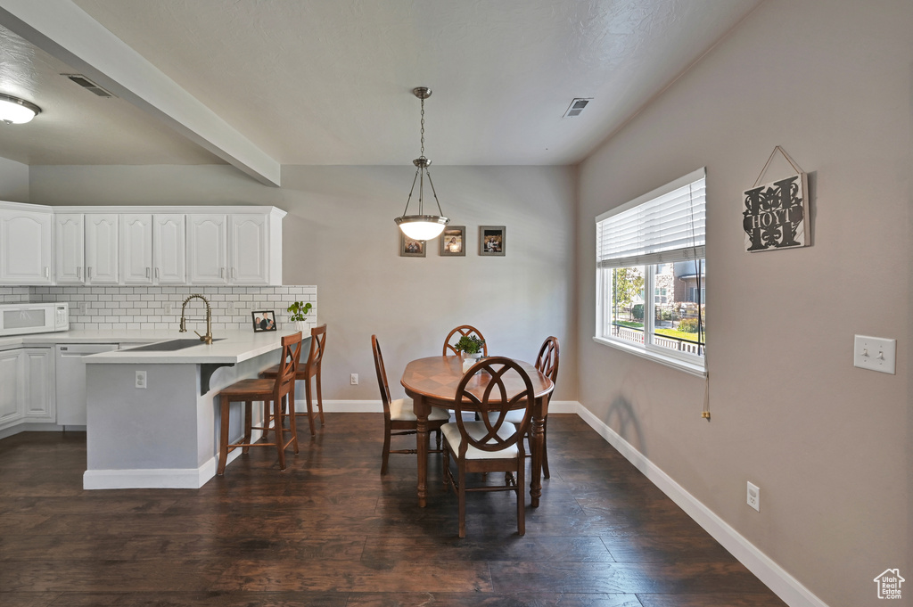 Dining area featuring dark wood-type flooring and sink