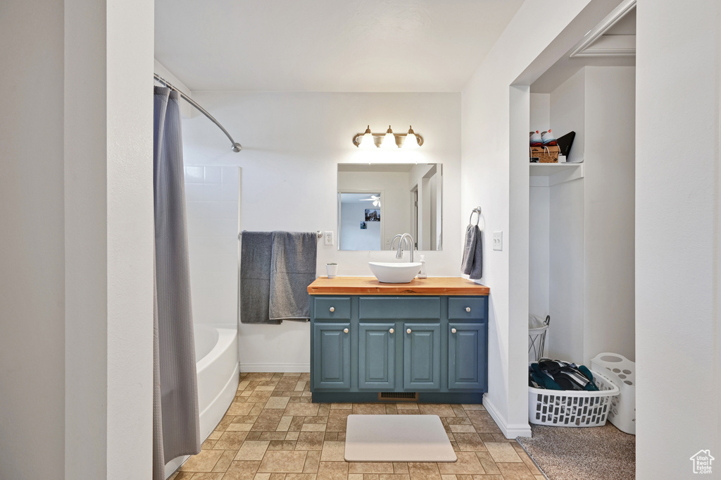 Bathroom featuring shower / tub combo with curtain and vanity