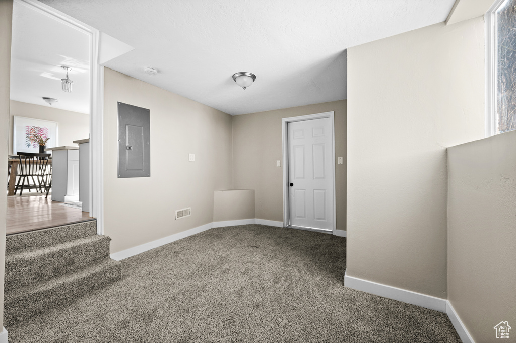 Carpeted empty room featuring electric panel