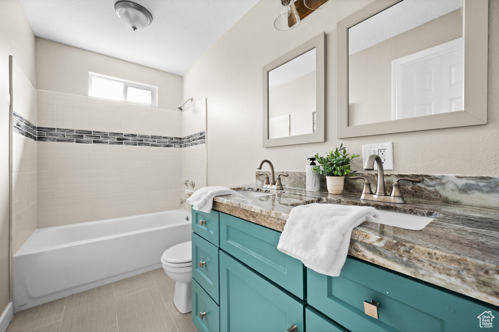 Full bathroom with tiled shower / bath, vanity, and toilet