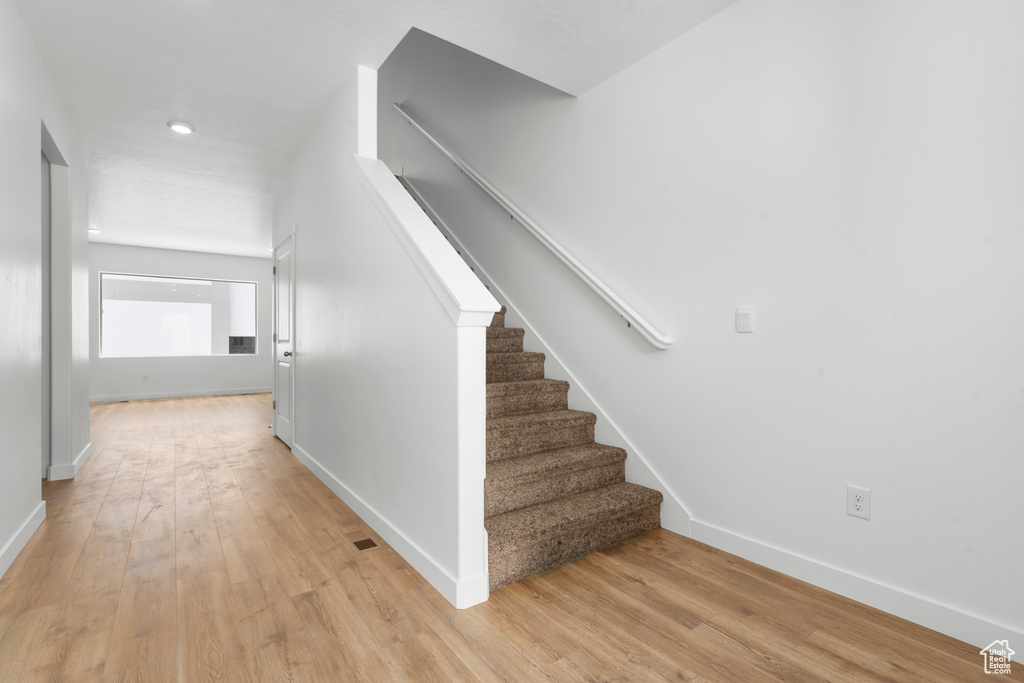 Stairway featuring hardwood / wood-style flooring