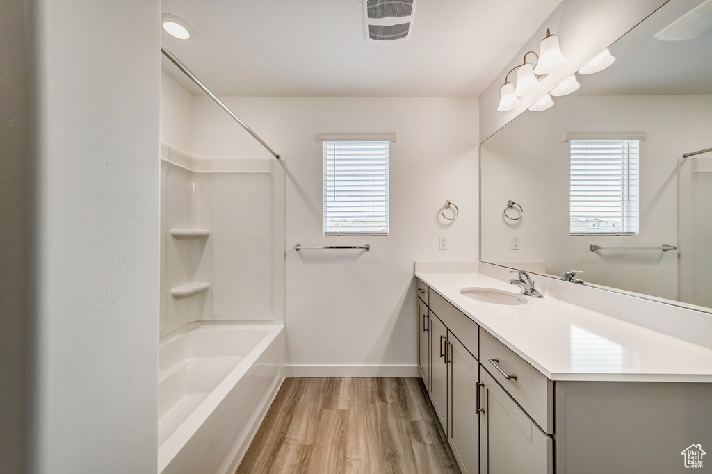 Bathroom featuring shower / bath combination, hardwood / wood-style flooring, and vanity