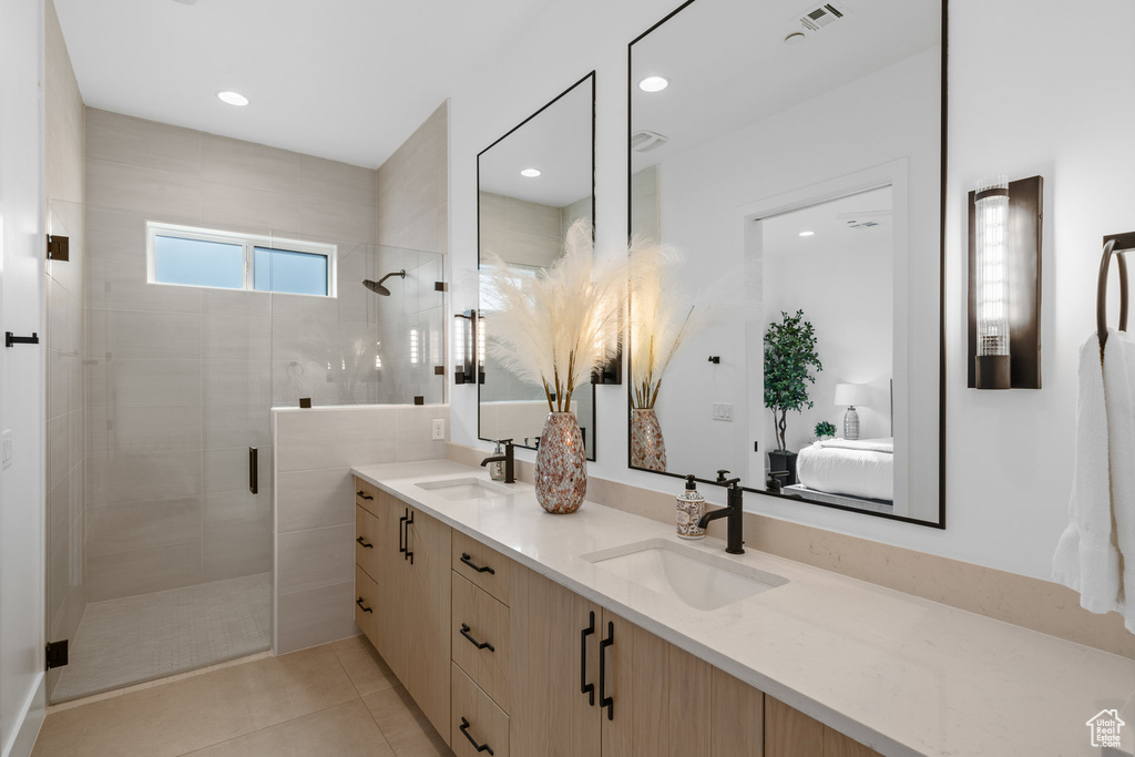 Bathroom with tile patterned floors, an enclosed shower, and vanity