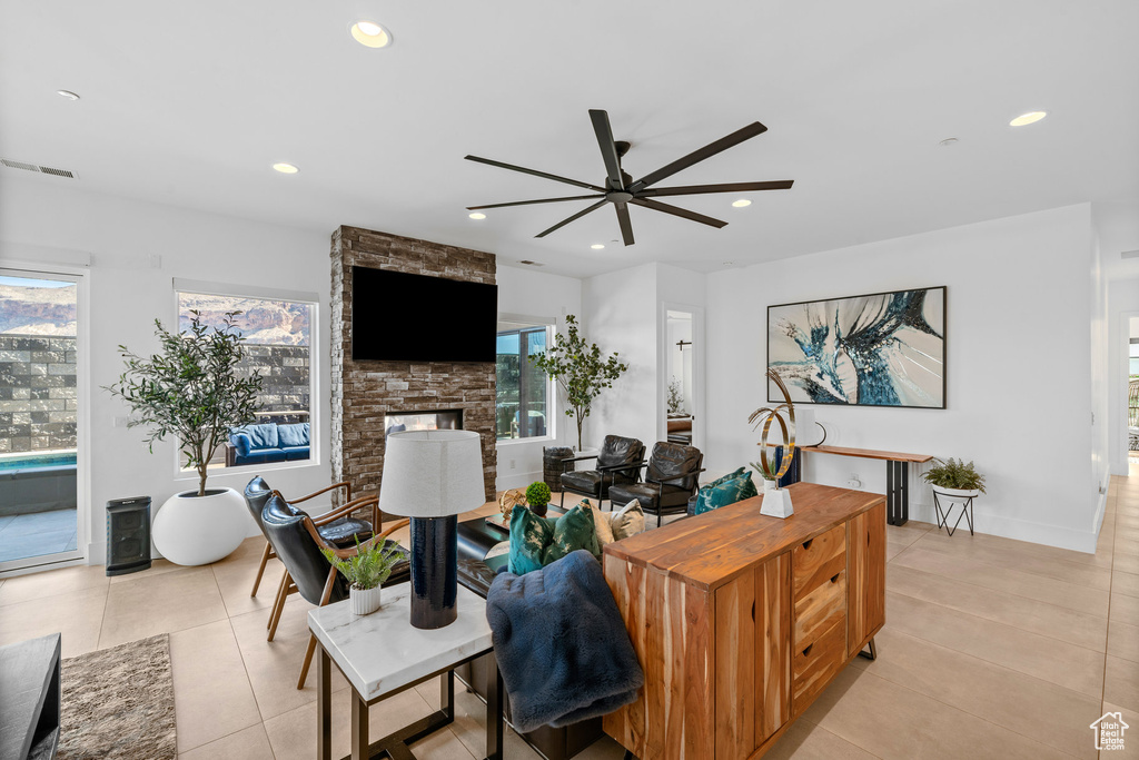 Living room featuring light tile patterned flooring, a fireplace, and ceiling fan