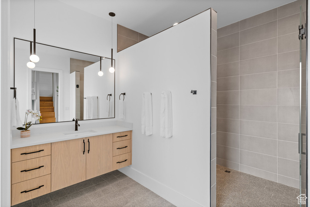 Bathroom featuring a tile shower and vanity