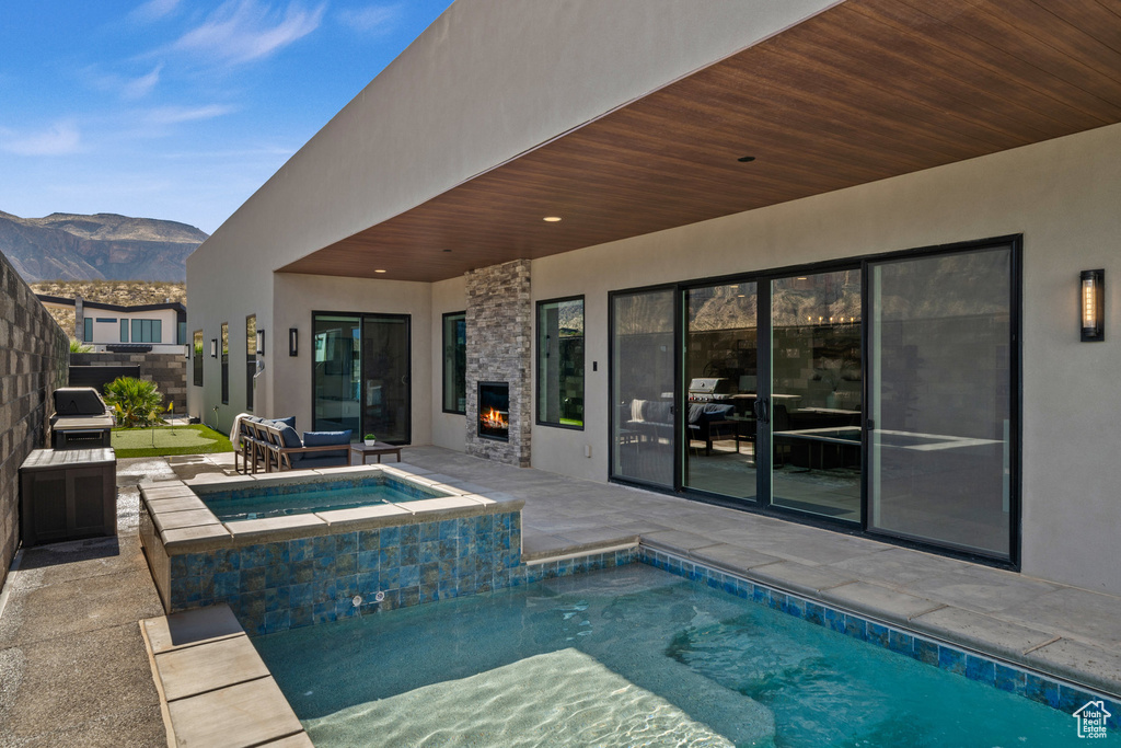 View of pool with a mountain view, an in ground hot tub, and a patio area