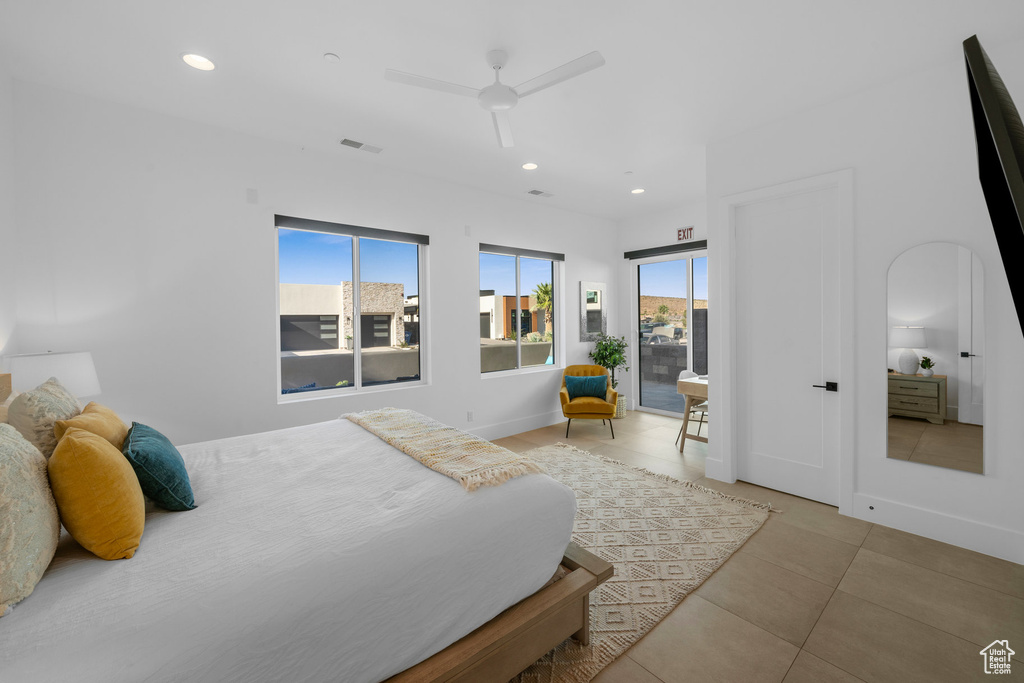 Bedroom with multiple windows, ceiling fan, and light tile patterned floors