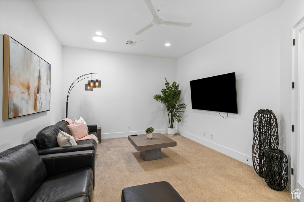 Carpeted living room featuring ceiling fan