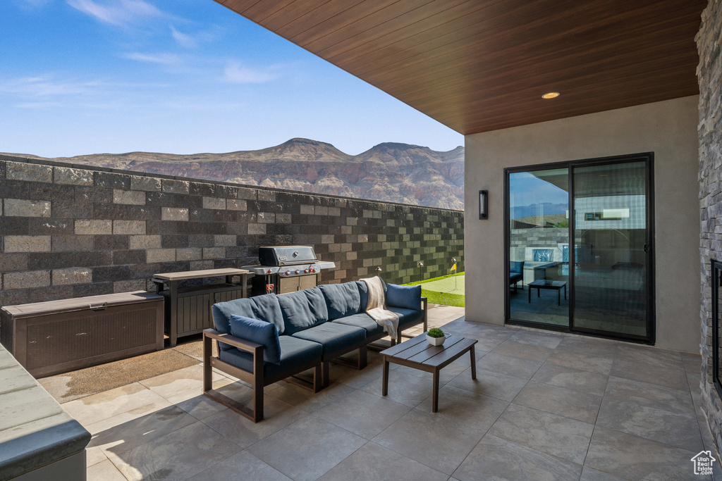 View of patio with a mountain view, an outdoor hangout area, and grilling area