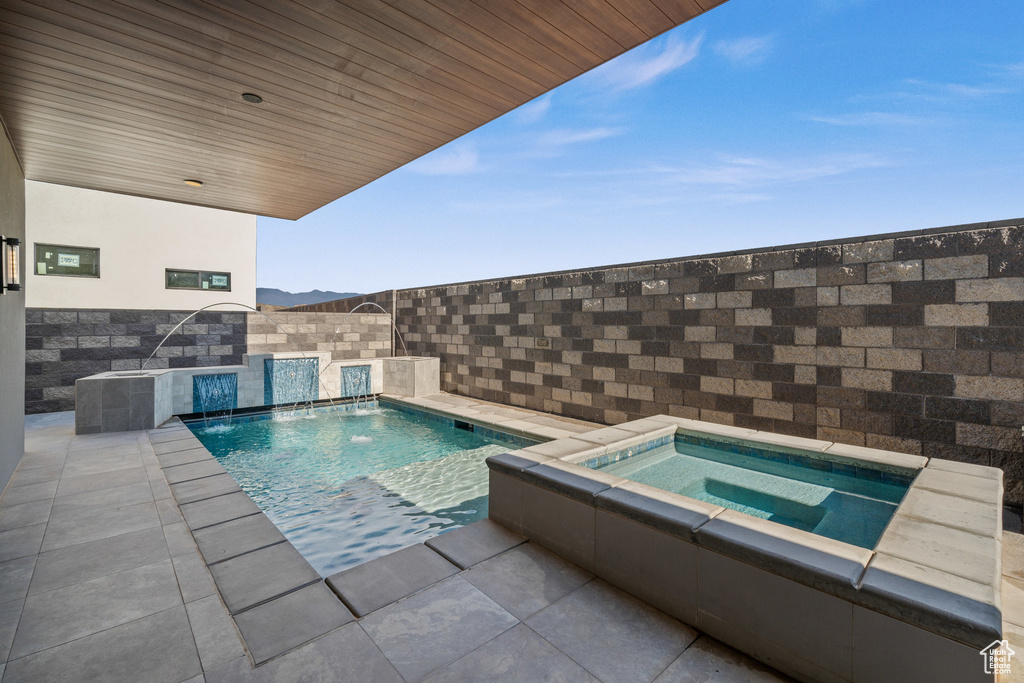 View of pool featuring an in ground hot tub and pool water feature