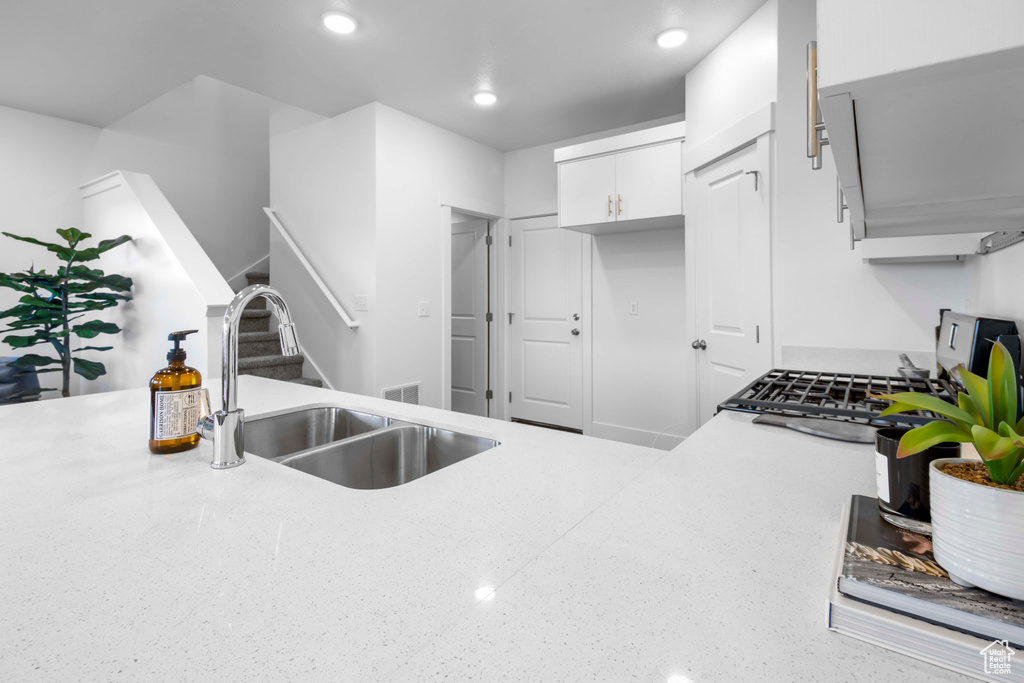 Kitchen featuring white cabinetry and sink