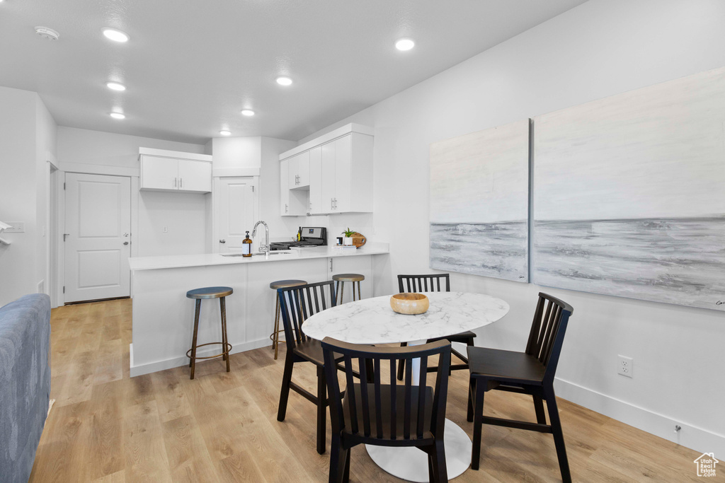 Dining area with sink and light hardwood / wood-style floors