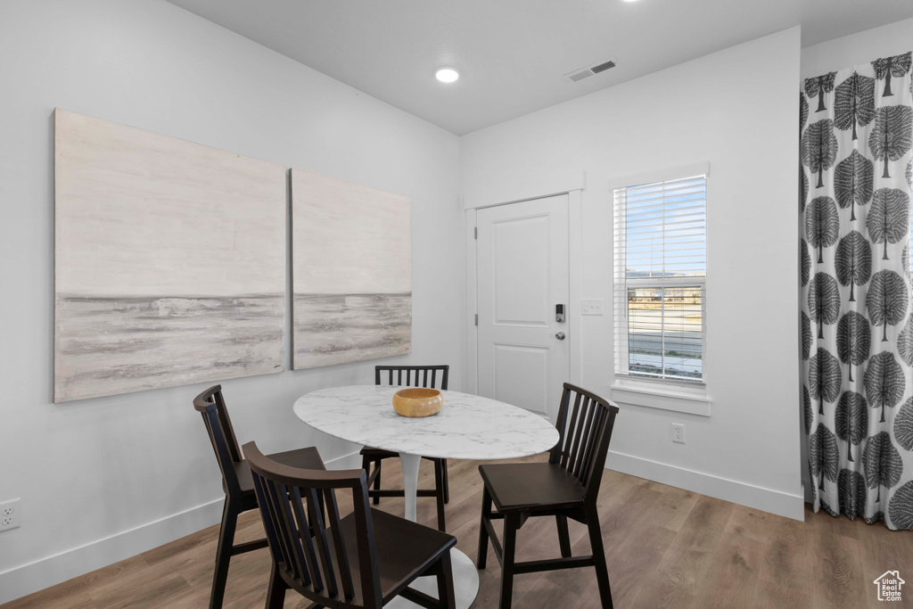 Dining space with hardwood / wood-style floors