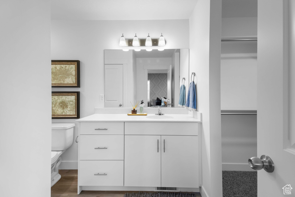 Bathroom with vanity, hardwood / wood-style floors, and toilet