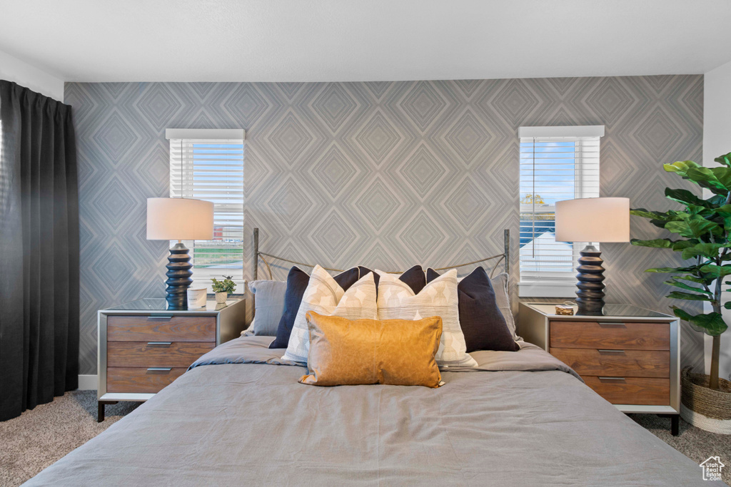 Carpeted bedroom featuring multiple windows