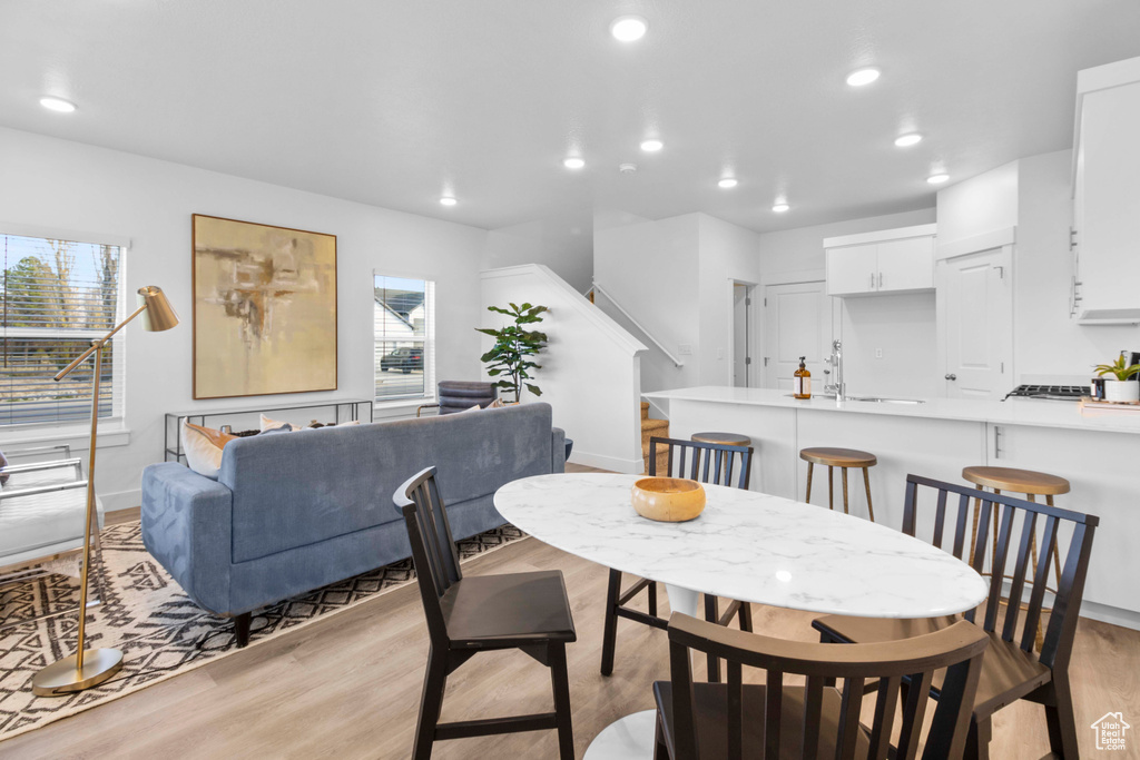 Dining area with light hardwood / wood-style flooring and a wealth of natural light