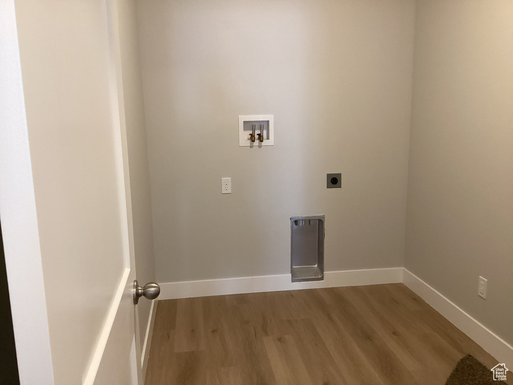 Laundry area featuring hookup for a washing machine, light hardwood / wood-style floors, and electric dryer hookup