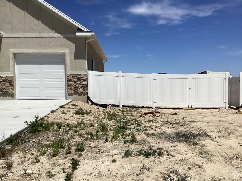 View of yard with concrete driveway, a gate, and a garage