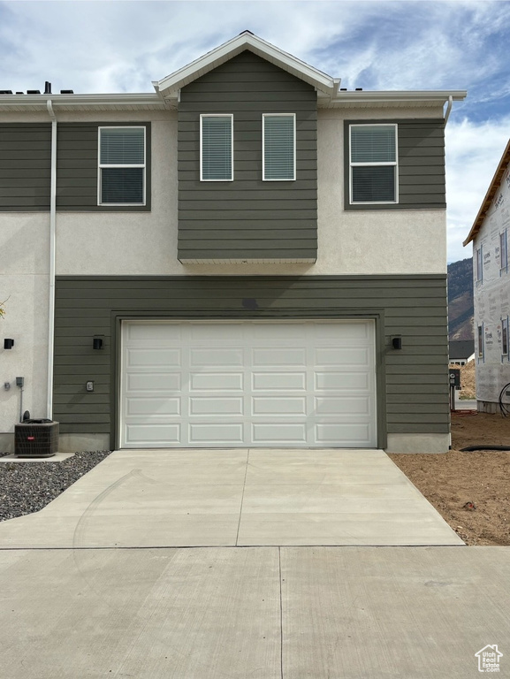 View of front facade with central AC and a garage