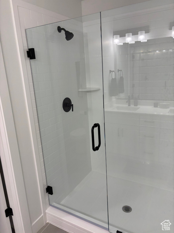 Bathroom featuring sink and a shower with shower door