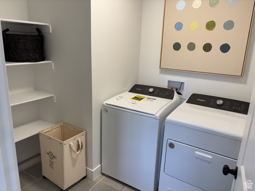 Laundry room featuring washer and clothes dryer and light tile patterned floors