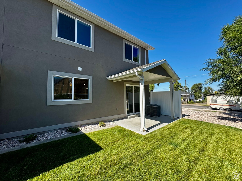 Rear view of property with a patio and a lawn