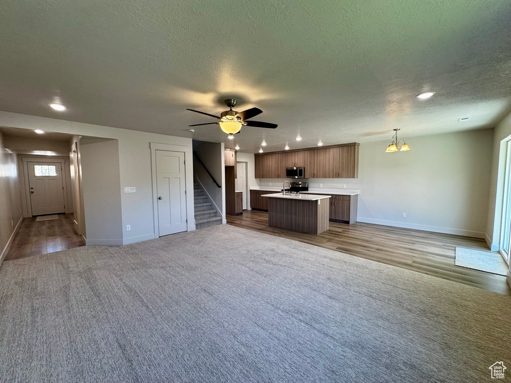 Unfurnished living room featuring wood-type flooring, a textured ceiling, and sink