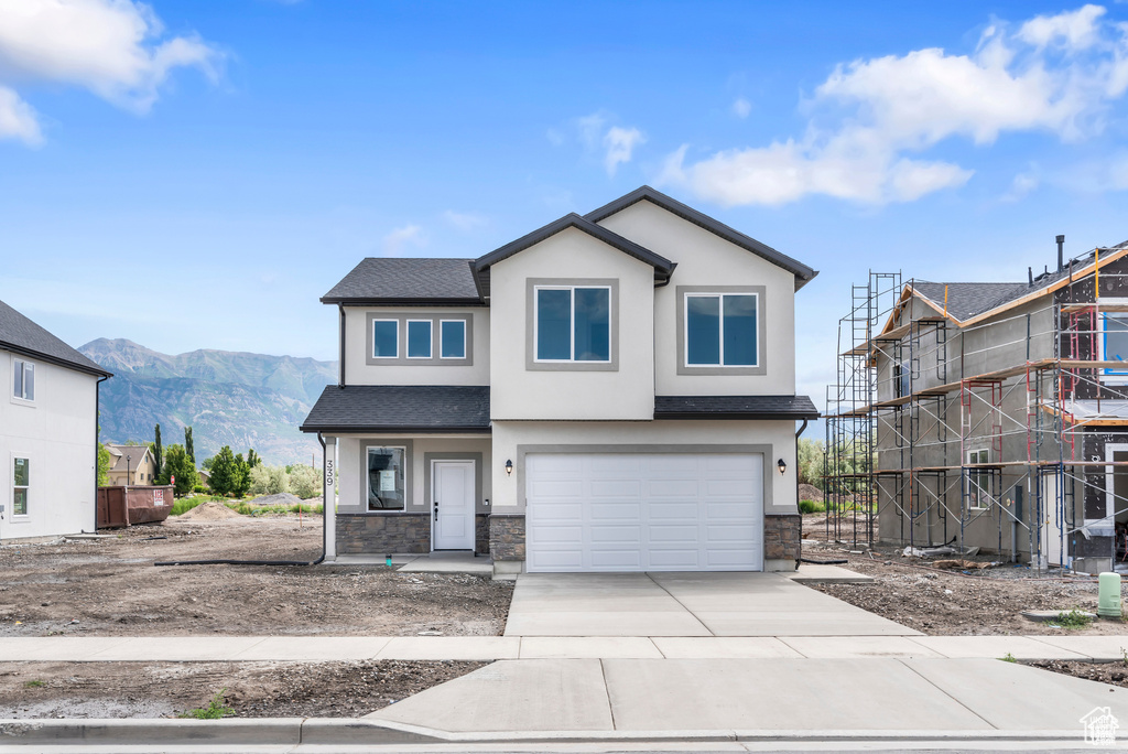 View of front of home featuring a mountain view and a garage