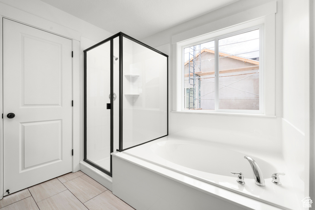 Bathroom with separate shower and tub and tile patterned flooring