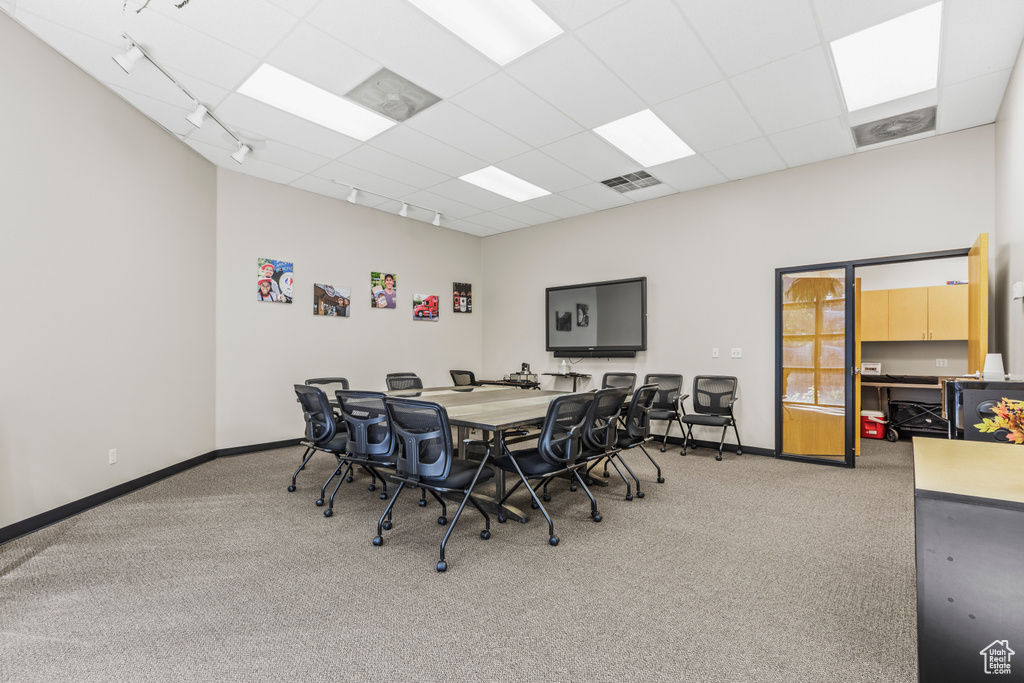 Carpeted dining space featuring a drop ceiling