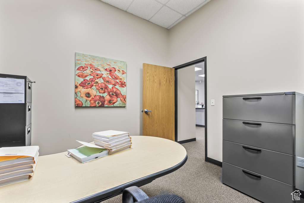 Carpeted home office featuring a drop ceiling