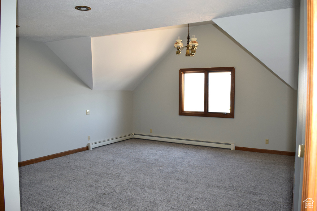 Additional living space with an inviting chandelier, lofted ceiling, carpet flooring, and a textured ceiling