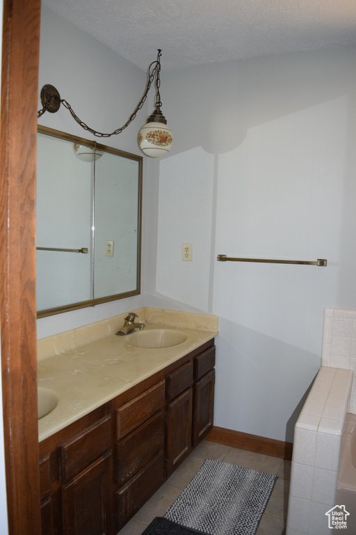 Bathroom with vanity, a textured ceiling, and tile patterned floors