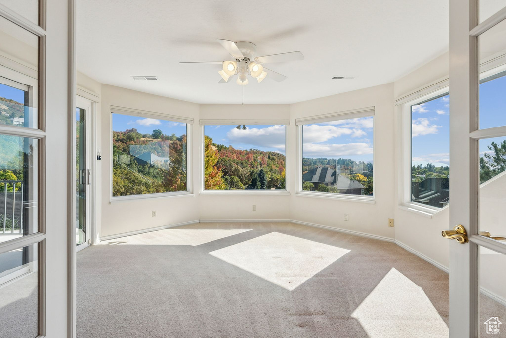 Unfurnished sunroom with ceiling fan