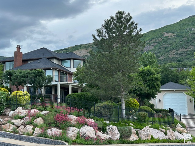 View of front of house featuring a mountain view, a balcony, and a garage