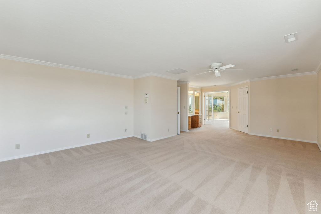 Carpeted empty room with ceiling fan and ornamental molding