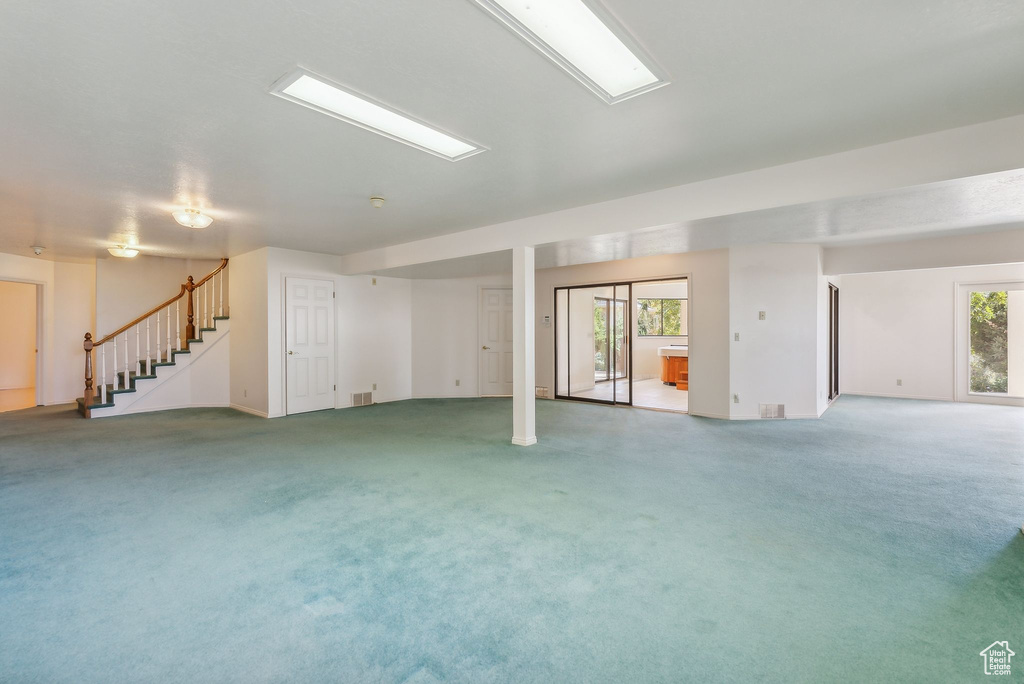 Basement with plenty of natural light and carpet