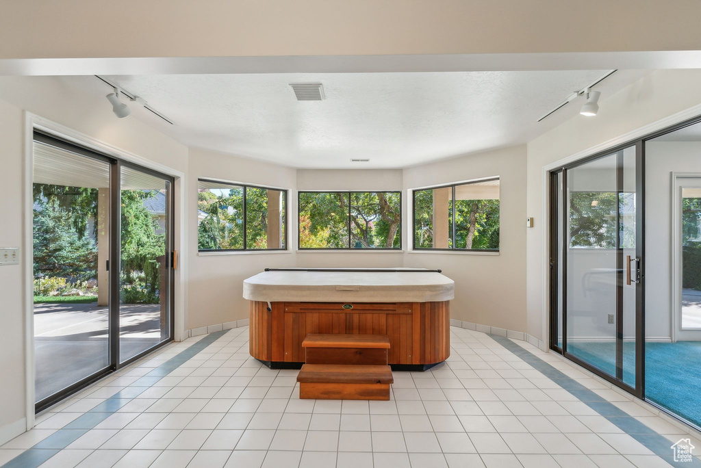 Miscellaneous room with plenty of natural light, a hot tub, and track lighting