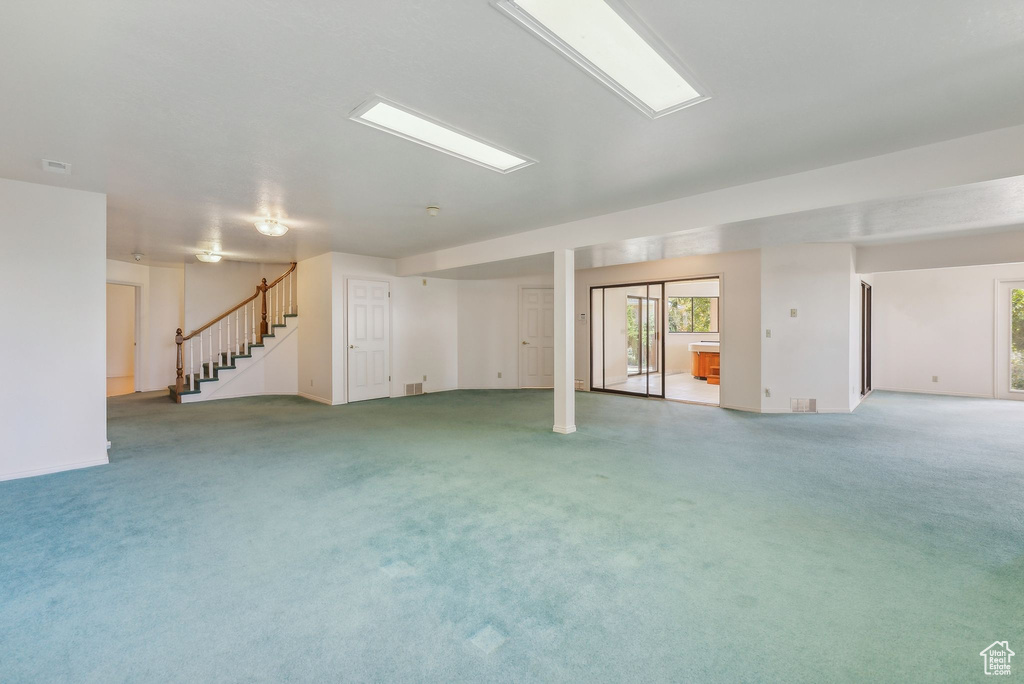 Basement featuring light colored carpet