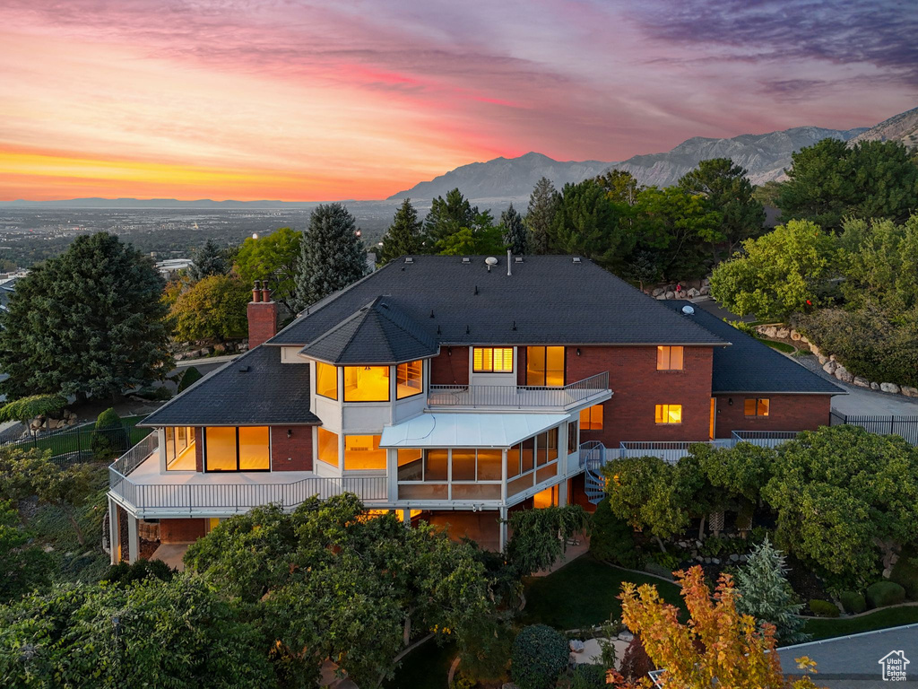 Back house at dusk with a mountain view and a balcony