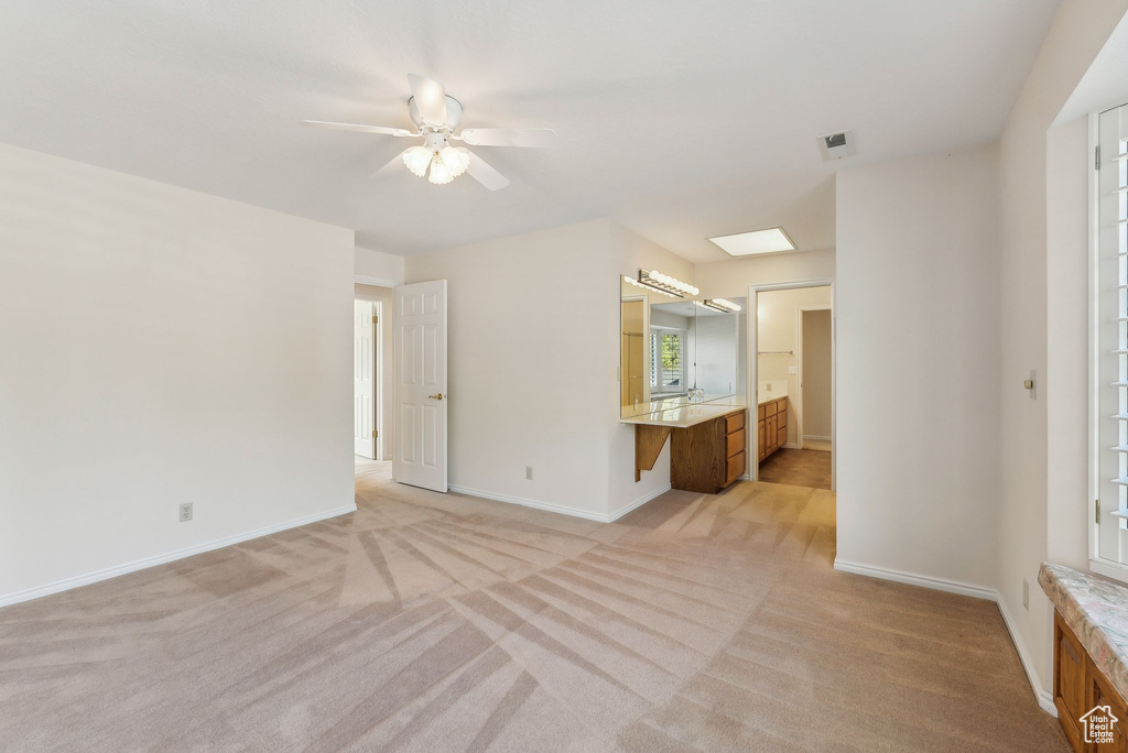 Interior space with ceiling fan and light colored carpet